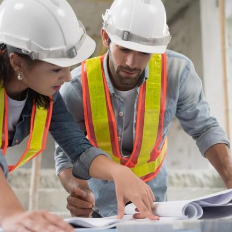 Working of engineer at building site talking and discussing on document . Teamwork site inspector and discuss together